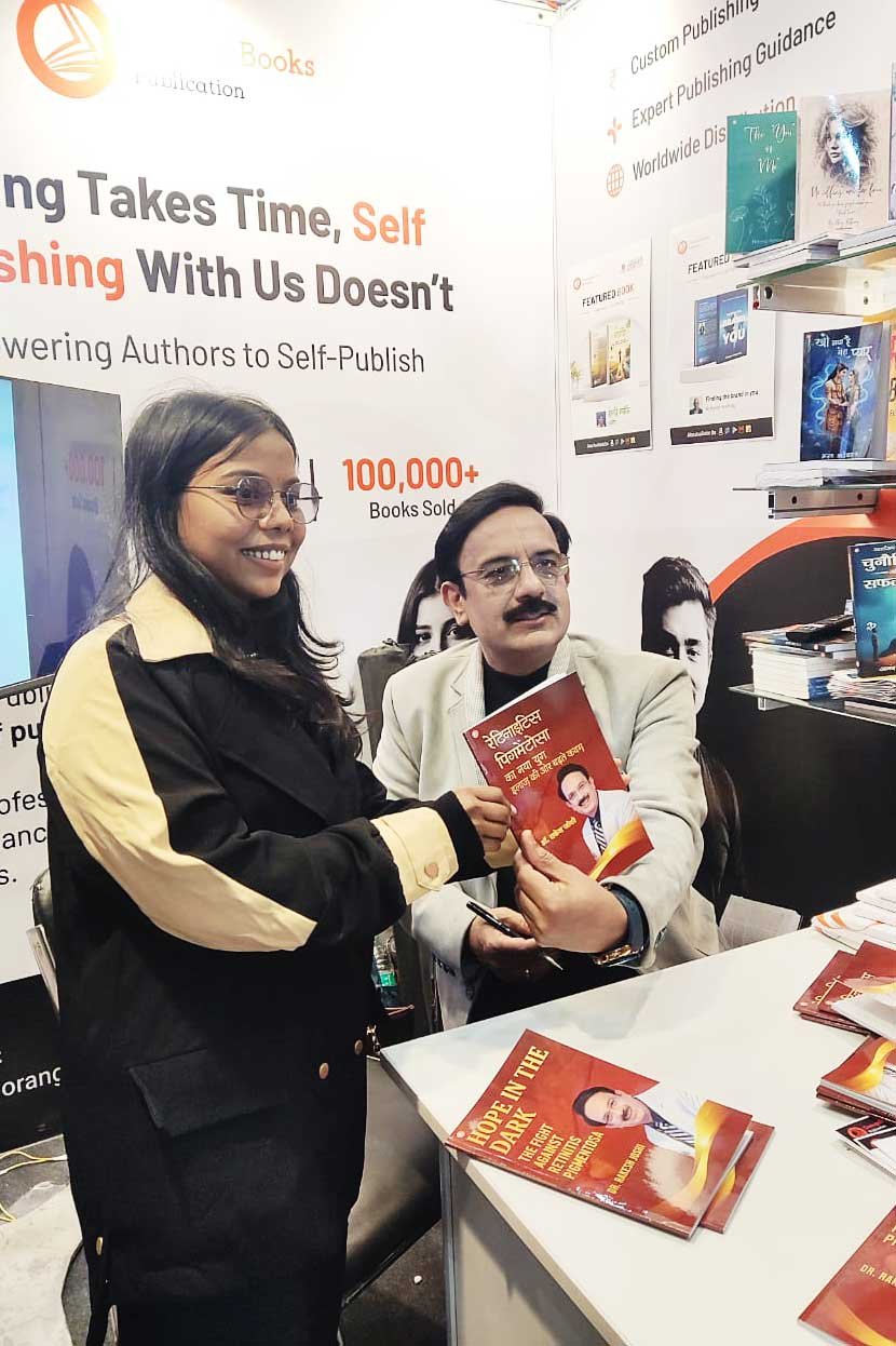 Dr. Rakesh Joshi handing a signed copy to a reader at NDWBF 2026